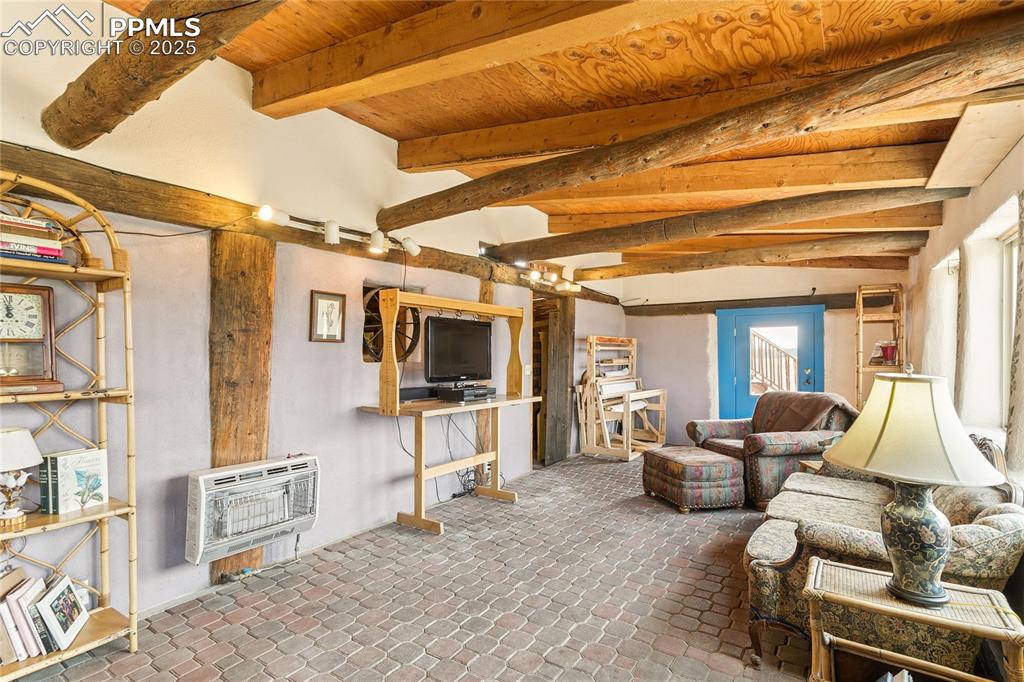Image 22 of 50: Living area with beamed ceiling and heating unit