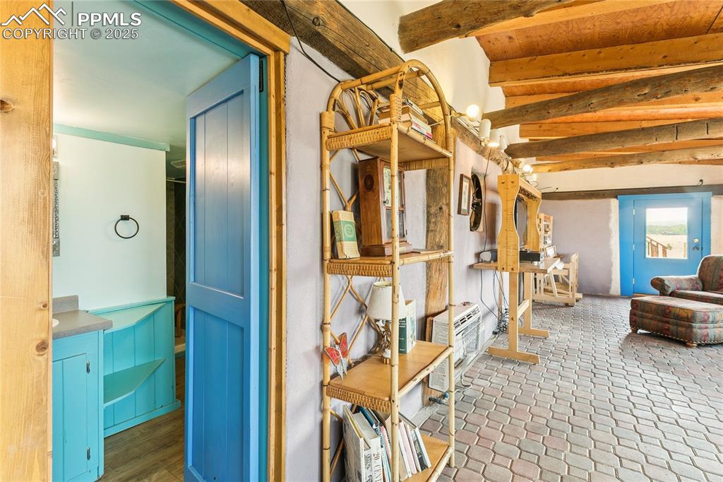 Image 25 of 50: Sitting room with beamed ceiling and heating unit