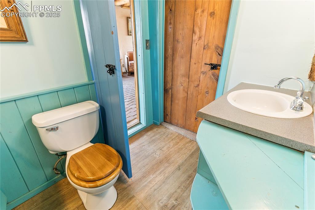 Image 29 of 50: 3//4 bathroom featuring vanity, light wood-style floors, and a wainscoted w