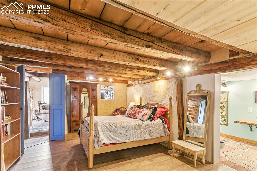 Image 33 of 50: Bedroom featuring a wood ceiling with exposed beams and baseboards