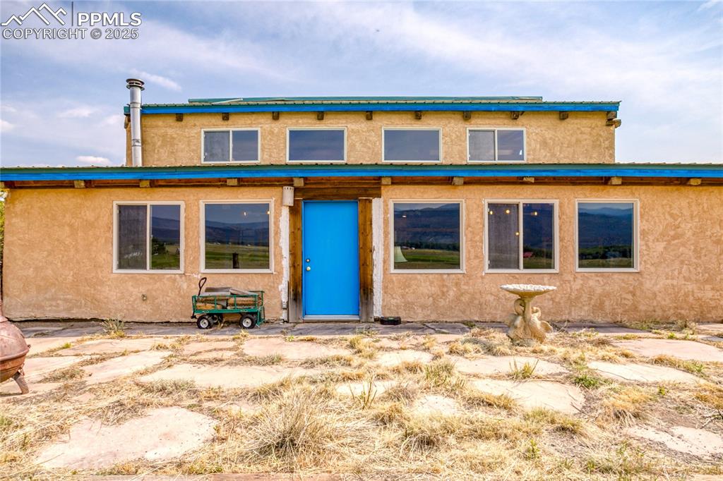 Image 4 of 50: View of front facade with stucco siding facing the South