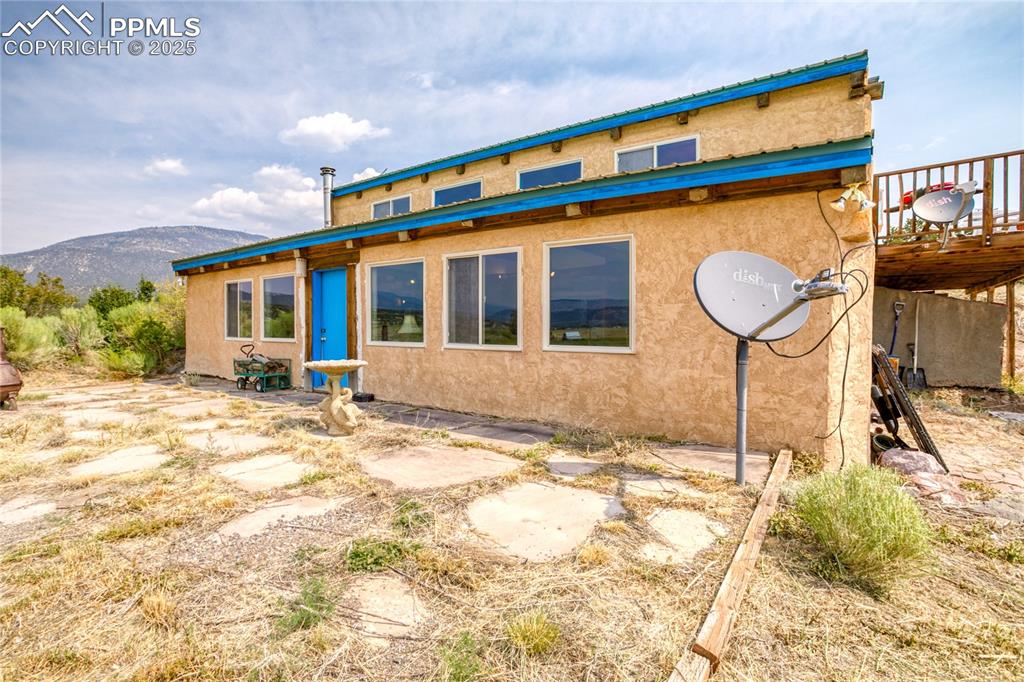Image 5 of 50: Rear view of property with stucco siding and a mountain view