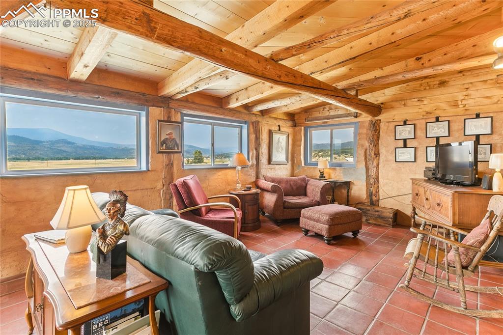 Image 9 of 50: Living area featuring light tile patterned flooring and a wooden ceiling wi