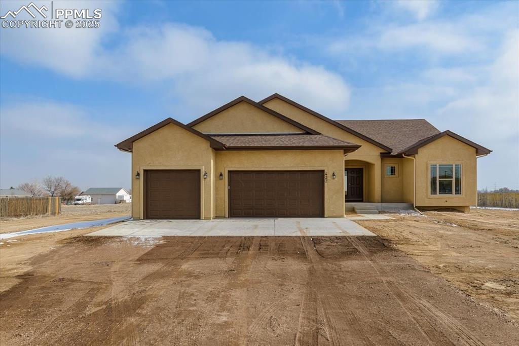 Image 2 of 45: View of front of home with an attached garage and stucco siding