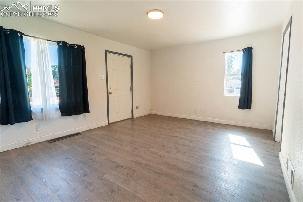 Image 4 of 11: Unfurnished bedroom with hardwood / wood-style floors and baseboards