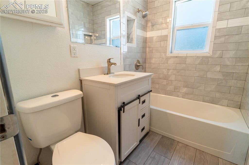 Image 7 of 11: Bathroom featuring vanity, healthy amount of natural light, shower / washtu
