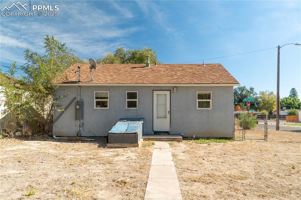 Image 9 of 11: View of front of home with a gate, roof with shingles, and stucco siding