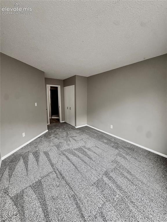 Image 10 of 20: Neutral gray wall paint, patterned carpet, white baseboards, and a built-in