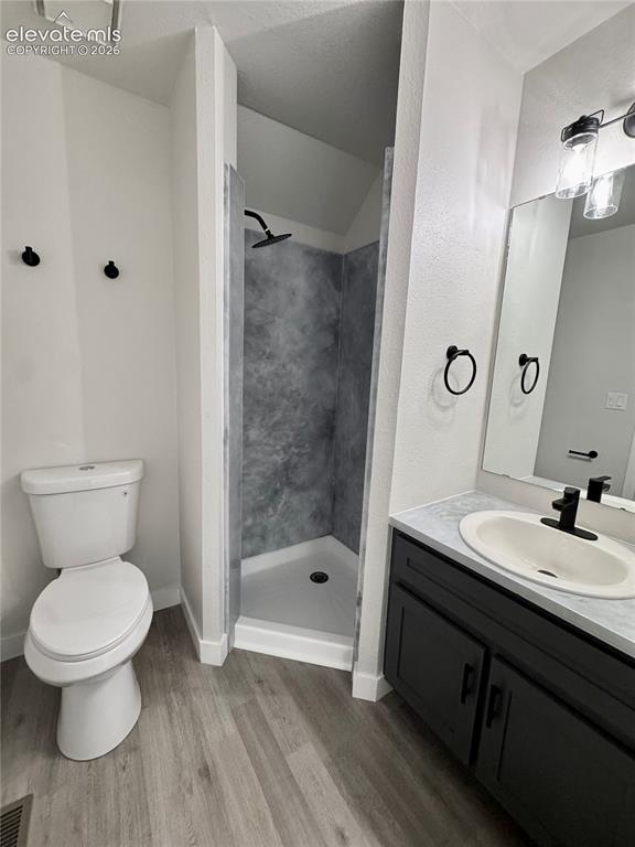 Image 12 of 20: Walk-in shower with dark-toned surround, vanity with dark cabinetry, integr