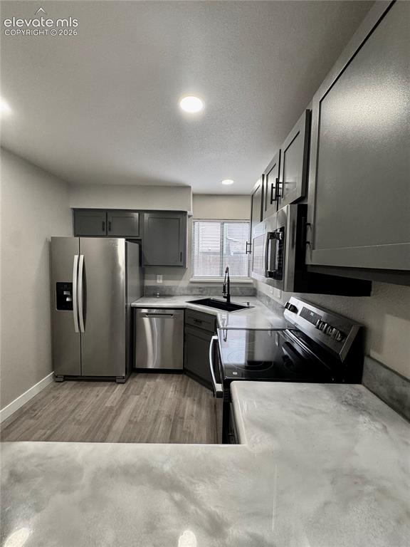 Image 6 of 20: Updated kitchen featuring wood-finish flooring, stainless steel appliances,