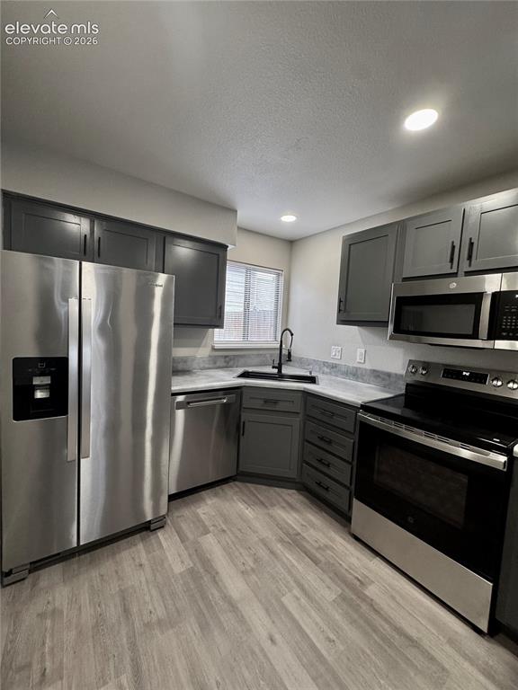 Image 8 of 20: Kitchen featuring stainless steel appliances, grey cabinetry, light-toned c