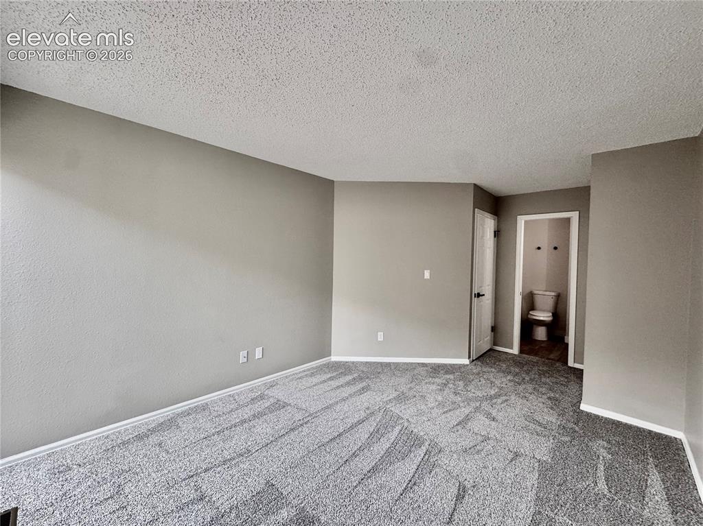 Image 9 of 20: Textured light gray walls with white trim, new gray patterned carpet, and a