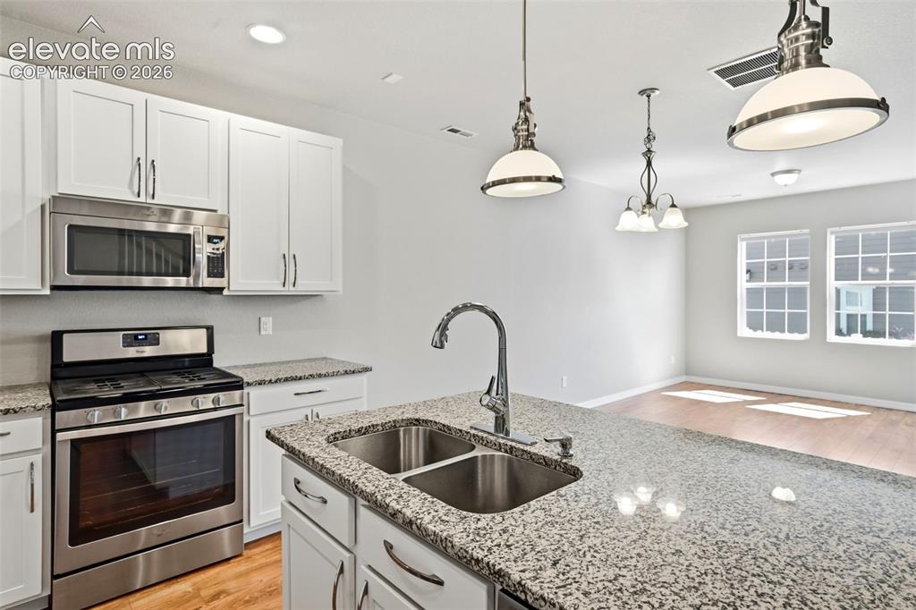 Image 20 of 45: Spacious Kitchen featuring a double basin stainless steel sink, granite cou