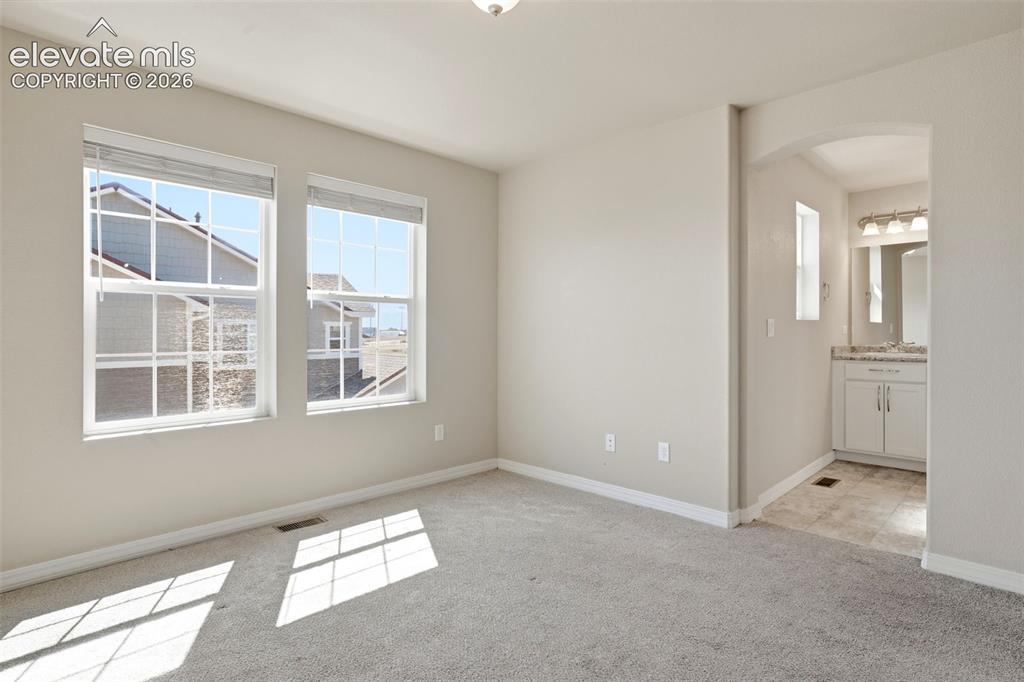 Image 31 of 45: Primary Bedroom with large windows.