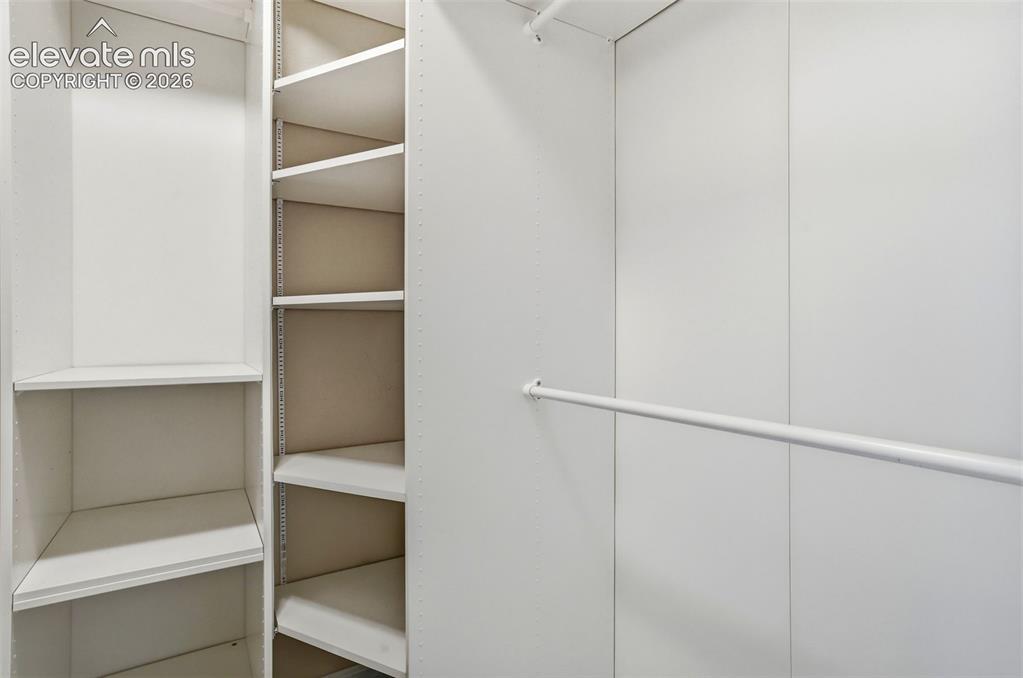 Image 34 of 45: Built-in primary bedroom closet organization system featuring multiple shel
