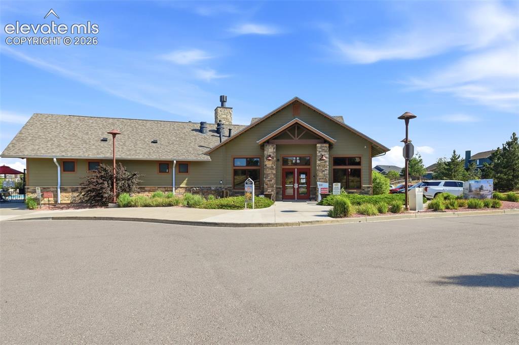 Image 43 of 45: Clubhouse facility featuring a gabled entryway with stone columns, a stone 