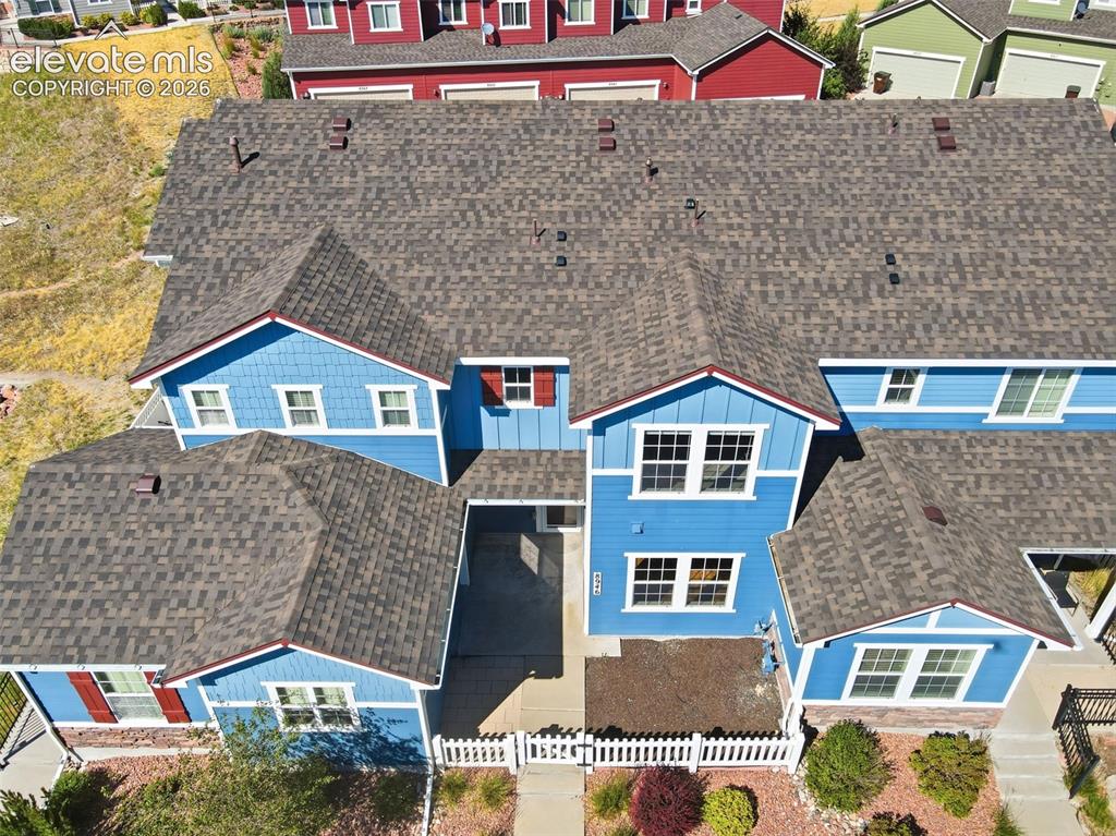 Image 5 of 45: Multi-level roofline with fenced patio area.