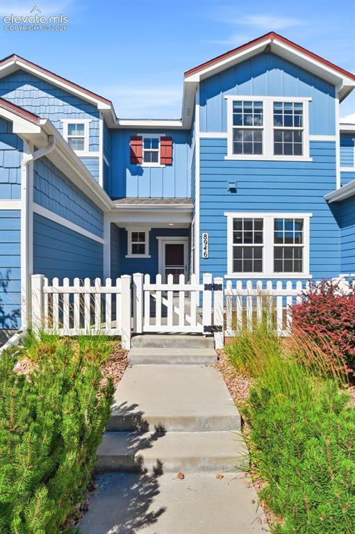 Image 8 of 45: Vibrant blue exterior with white trim and red accent shutters.