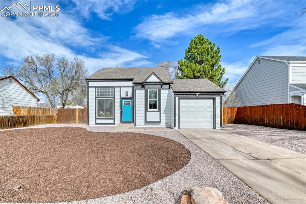 Caption: View of front facade featuring concrete driveway, a garage, and roof with shingles