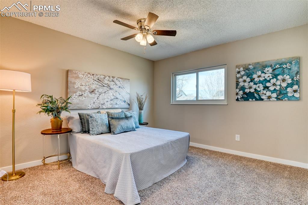 Image 19 of 44: Carpeted bedroom featuring a ceiling fan and a textured ceiling