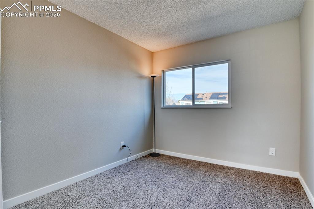 Image 26 of 44: Carpeted spare room featuring baseboards and a textured ceiling