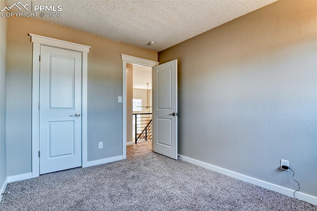 Image 27 of 44: Unfurnished bedroom with carpet floors and a textured ceiling