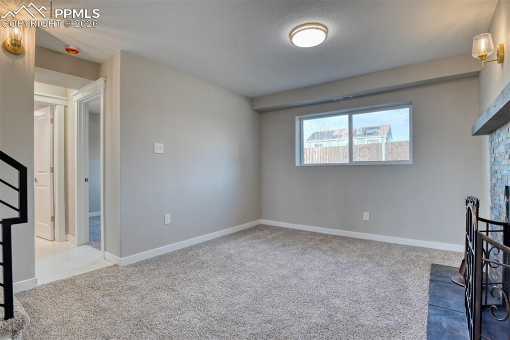 Image 32 of 44: Unfurnished living room featuring light carpet and a fireplace