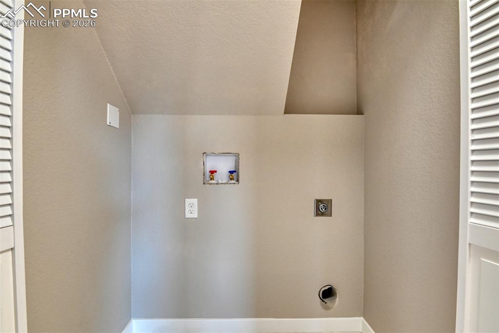 Image 38 of 44: Laundry room with a textured wall, electric dryer hookup, lofted ceiling, a