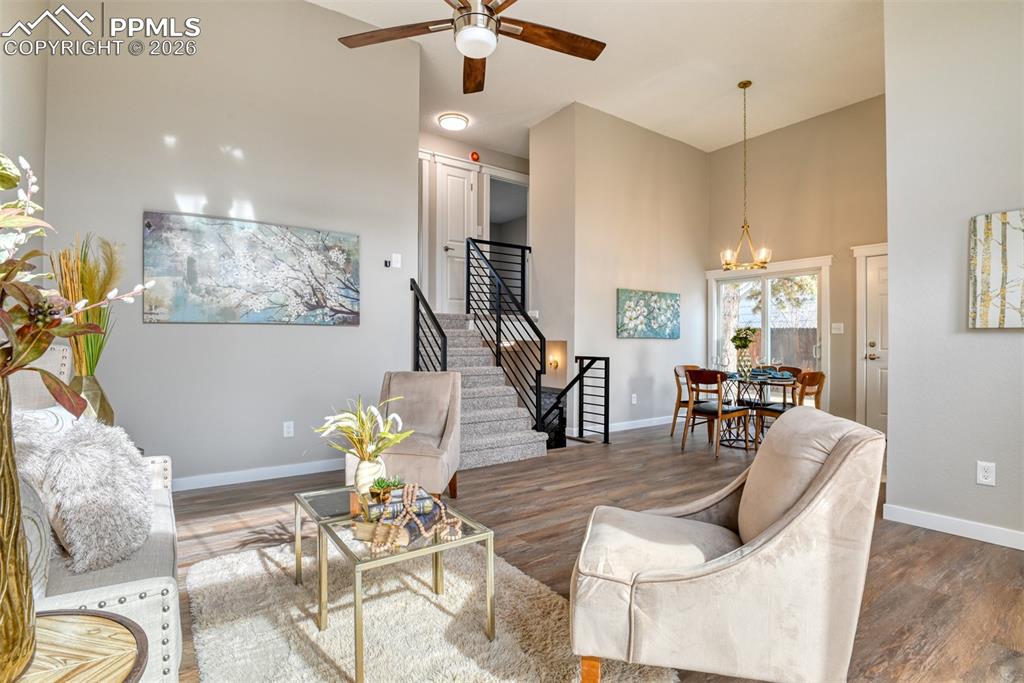 Image 7 of 44: Living area with a high ceiling, wood finished floors, ceiling fan, and a c