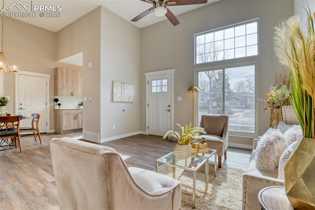 Image 8 of 44: Living room featuring a high ceiling, light wood-style flooring, a ceiling 