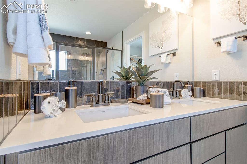 Image 12 of 32: Full bathroom featuring a stall shower, double vanity, and recessed lightin