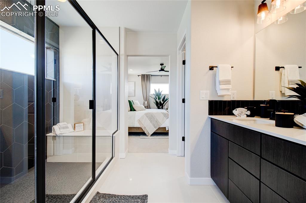 Image 13 of 32: Bathroom with vanity, ensuite bathroom, a shower stall, and a ceiling fan