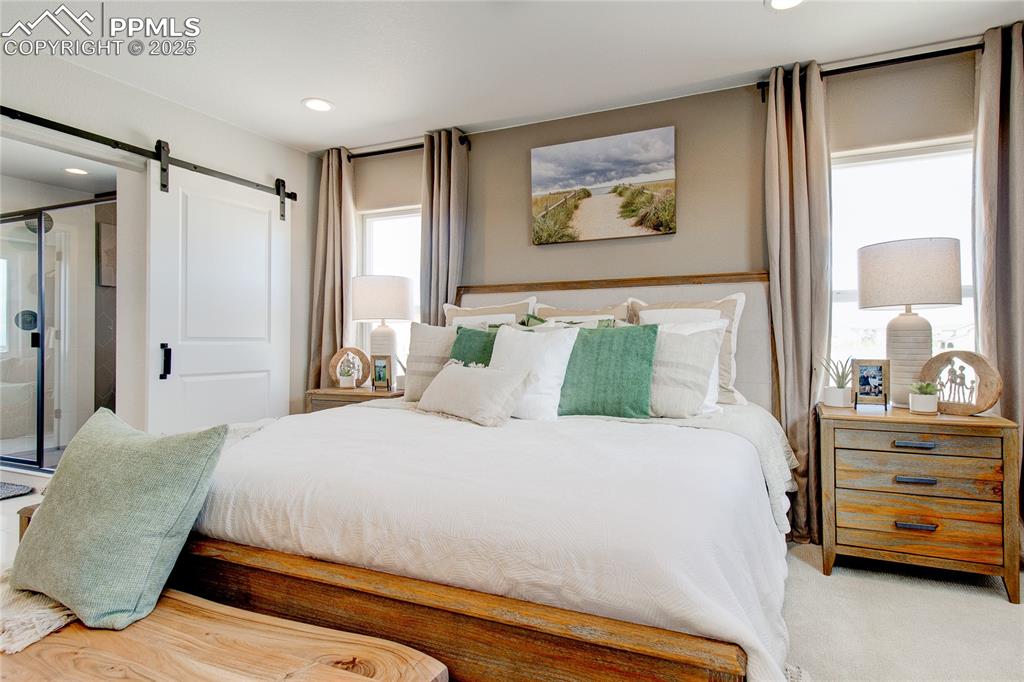 Image 9 of 32: Bedroom featuring a barn door, recessed lighting, and carpet floors