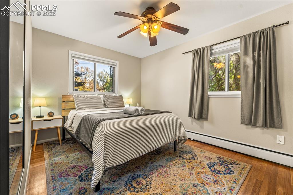 Image 14 of 42: Bedroom with light wood-style flooring, a baseboard radiator, and a ceiling