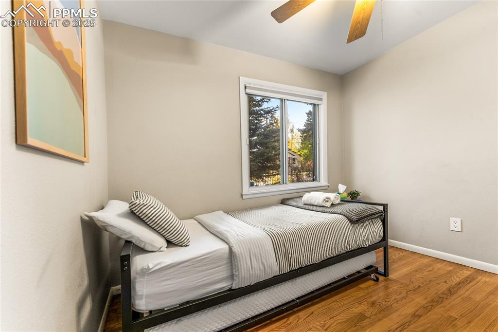 Image 20 of 42: Bedroom with wood finished floors and ceiling fan