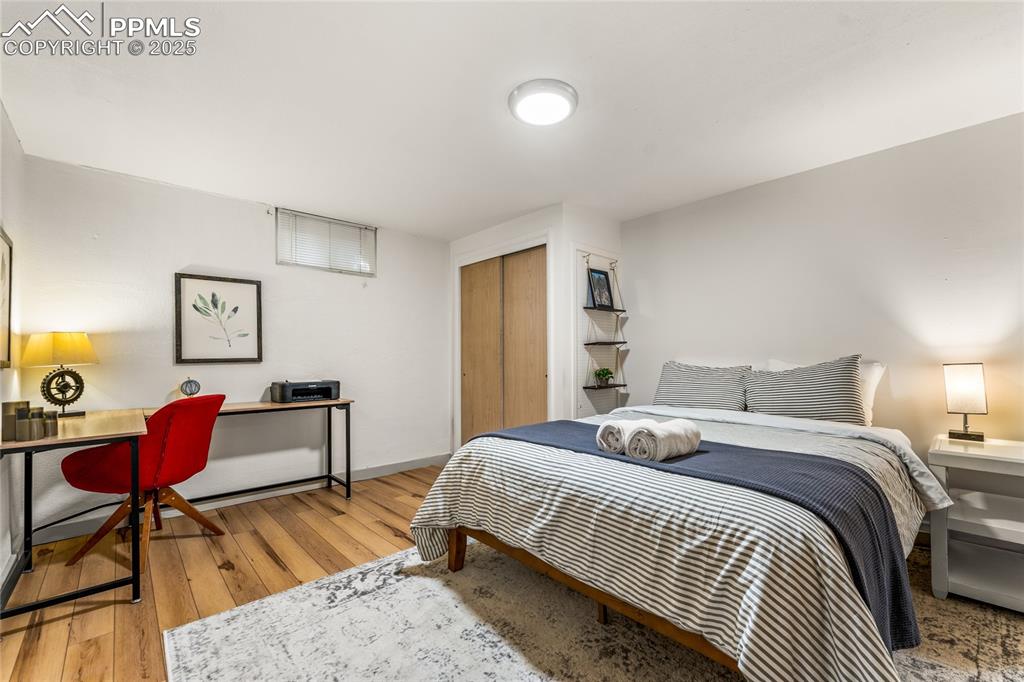 Image 27 of 42: Bedroom with a closet, light wood-style floors, and an office area