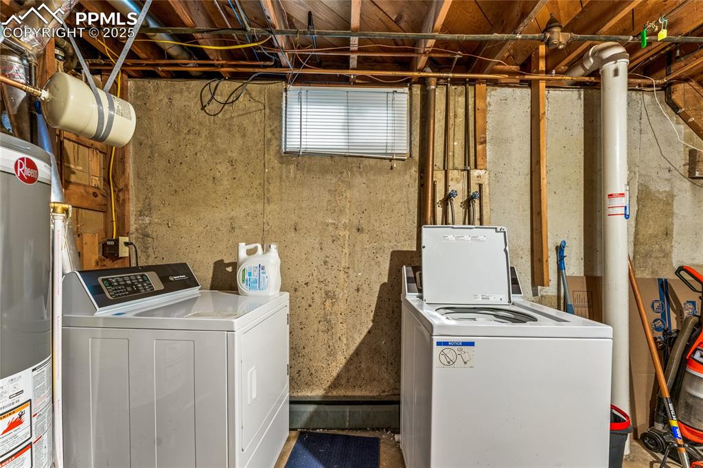 Image 30 of 42: Laundry area with water heater and separate washer and dryer