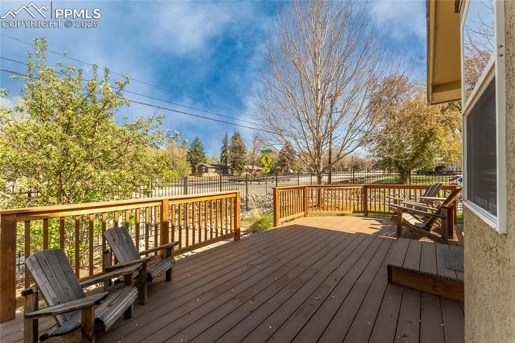 Image 33 of 42: Wooden terrace with a fenced backyard
