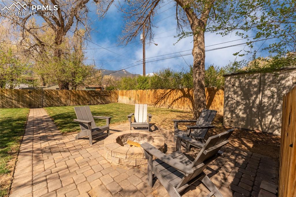 Image 35 of 42: Fenced backyard featuring an outdoor fire pit and a patio area