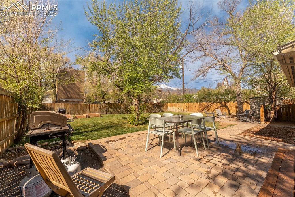 Image 36 of 42: Fenced backyard featuring a patio area and outdoor dining space