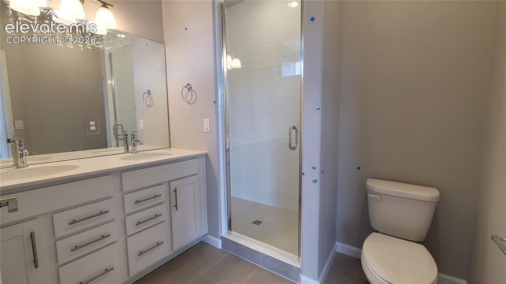 Image 27 of 32: Primary Bathroom with quartz countertop, double vanities, and tile surround