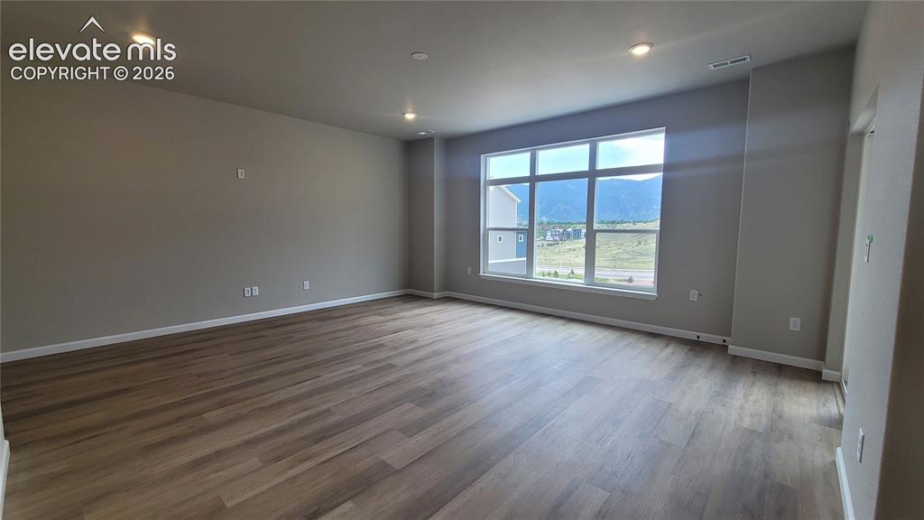 Image 9 of 32: Living room with LVP flooring, LED Lighting, Prewired for Future Ceiling Fa