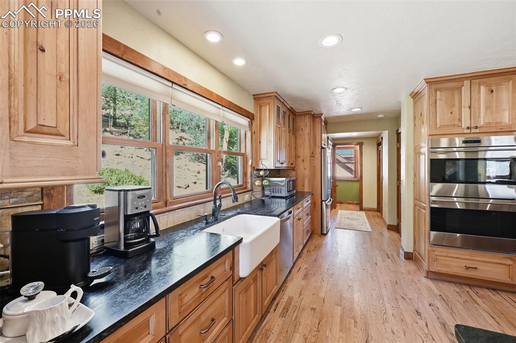 Image 20 of 50: Farmhouse sink is accompanied by picturesque windows, so you can get lost i