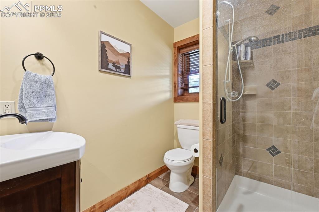 Image 34 of 50: Basement 3/4 bathroom provides a glass enclosed shower.