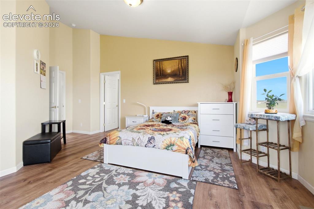 Image 12 of 44: Bright, sun-filled primary bedroom featuring glass sliding door access to b