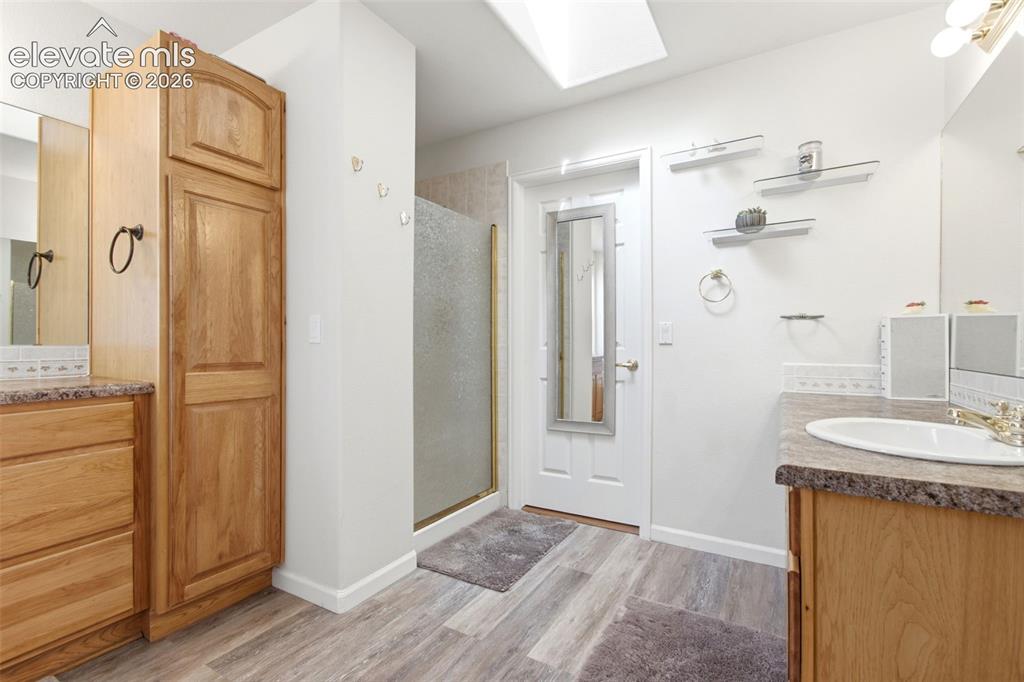 Image 18 of 44: Wood-finish flooring, built-in wooden cabinetry, vanity with integrated sin