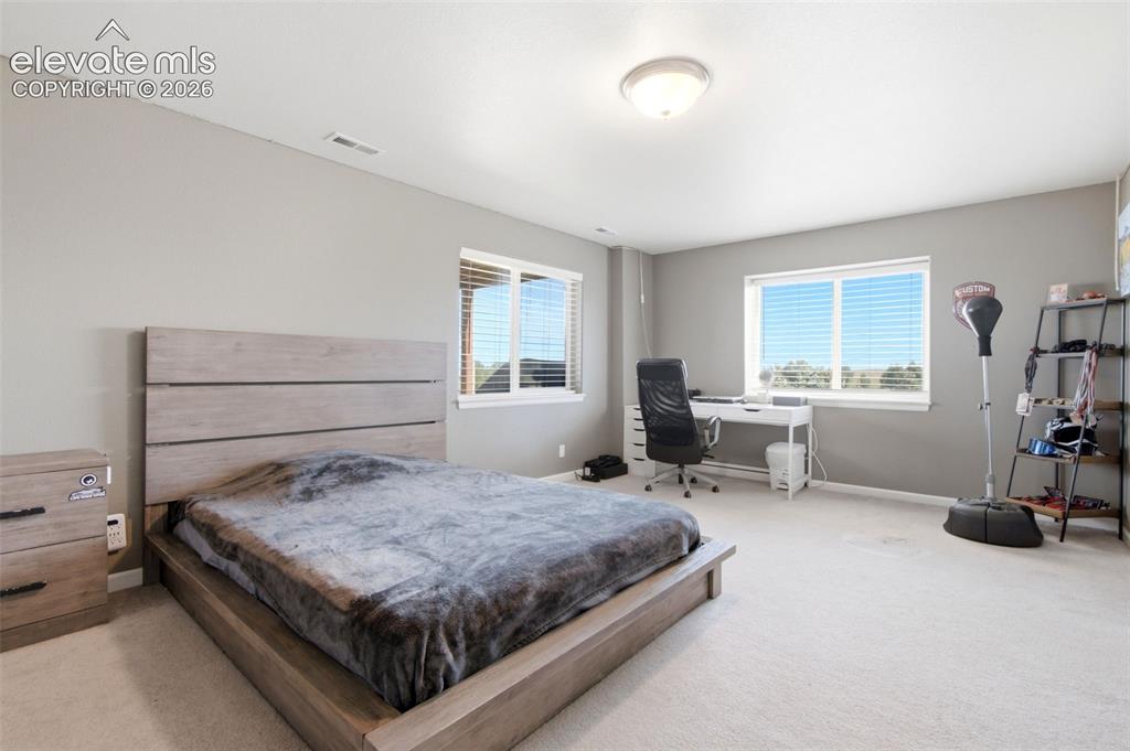 Image 26 of 44: Spacious primary bedroom featuring a horizontal plank-style headboard, abun