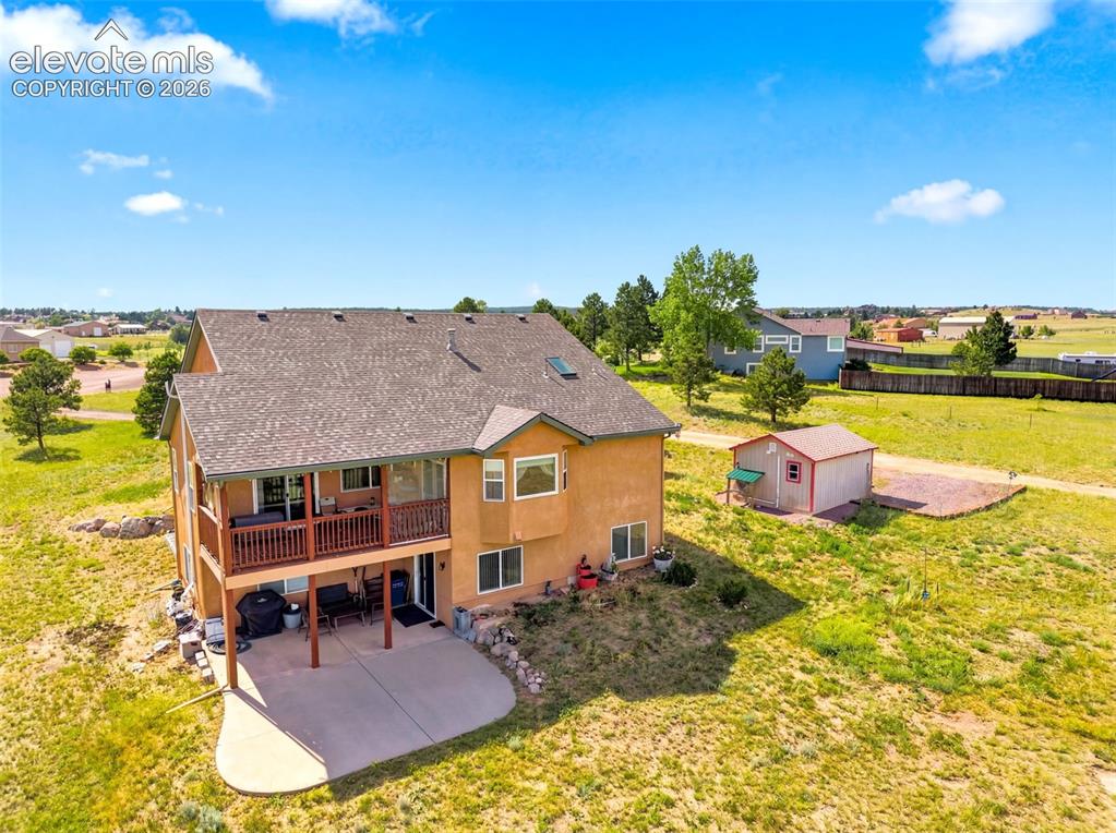 Image 36 of 44: Spacious two-story residence with warm exterior finish and deck, situated o