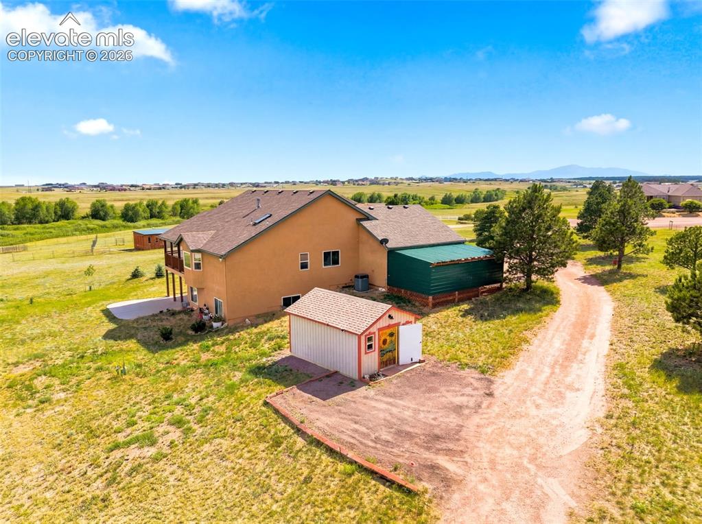 Image 37 of 44: Spacious rural property featuring a tan stucco residence 