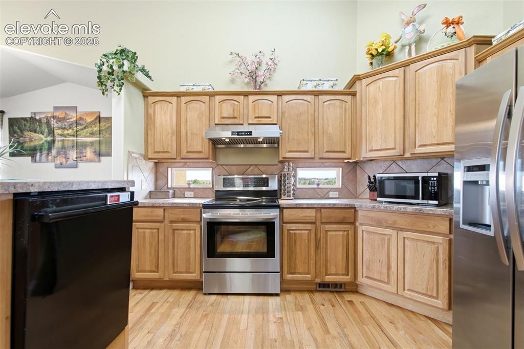 Image 4 of 44: Spacious kitchen featuring wood-finish cabinetry with raised-panel doors, s